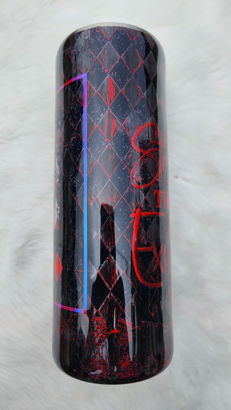 "Glossy tumbler with a dark gothic design featuring a queen-like woman with black wavy hair, blue eyes, and a jeweled crown with a red heart. She wears a black corset and lace sleeves, holding a large red heart in her hands. The background includes roses, playing card suits, and a red-and-black diamond harlequin pattern."